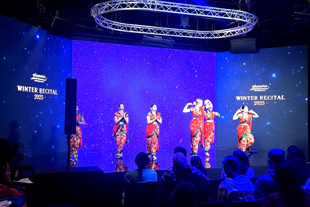 This image captures a vibrant performance at the Shawnee Performing Arts Winter Recital 2025, featuring five dancers in…
