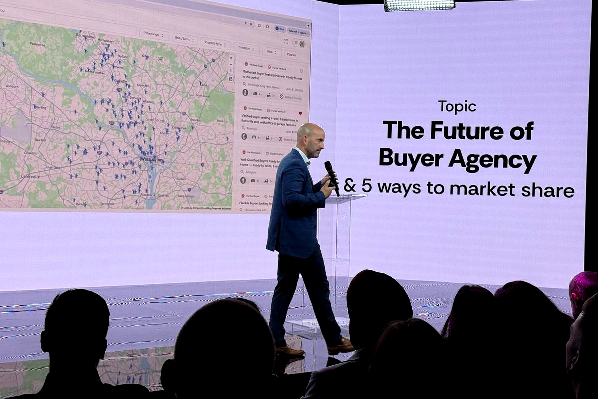 A professional speaker in a navy blazer presents on stage about